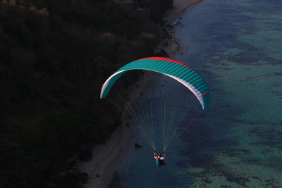 Person paragliding over water