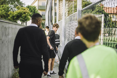 Portrait of teenage boy looking back while walking with friends