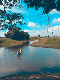 Man boating in lake against sky