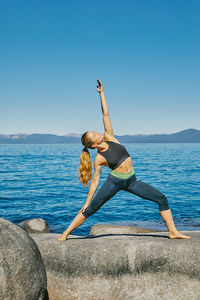 Young woman practicing yoga on lake tahoe in northern california.