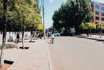 People walking on street amidst buildings in city