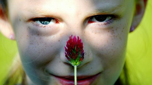 Close-up portrait of girl with pink flower