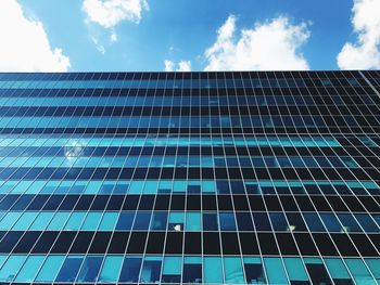 Low angle view of skyscraper against blue sky