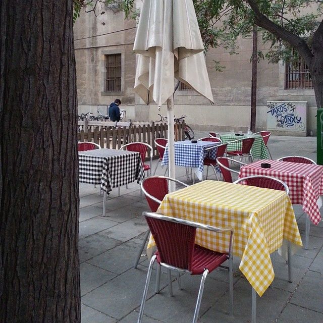 table, chair, food and drink, building exterior, absence, built structure, bench, architecture, sidewalk cafe, restaurant, food, empty, day, sunlight, house, wood - material, tree, outdoors, relaxation, seat