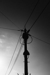 Low angle view of silhouette electricity pylon against sky