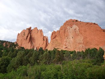 View of rocks and trees on rock against sky