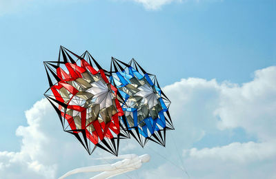 Low angle view of multi colored flags against blue sky