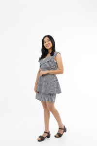 Portrait of smiling young woman against white background