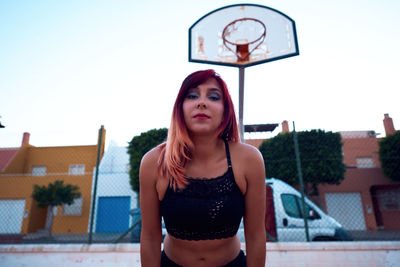 Girl with red hair on a basketball court. outdoor sports concept