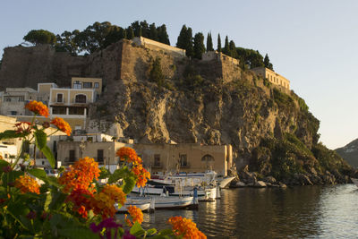 Boats in sea with buildings in background