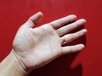 Close-up of person hand against red background