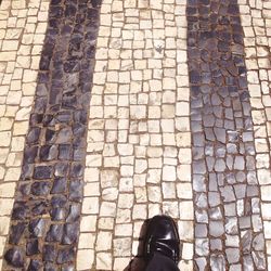 Low section of person standing on tiled floor