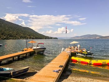 Sailboats moored on lake against sky