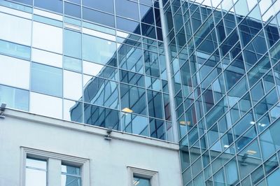 Low angle view of glass building against sky