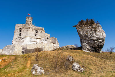 Low angle view of old building against clear blue sky