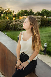 Beautiful young woman sitting outdoors