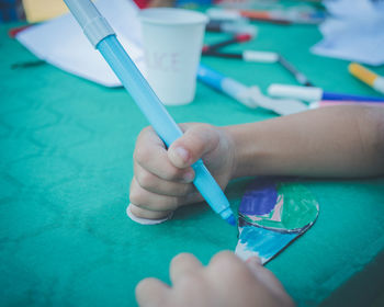 Cropped hand of person coloring over table