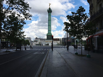 Road passing through city against sky
