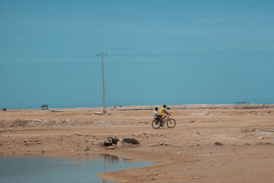 Man riding bicycle on shore