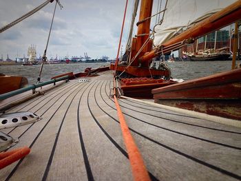 Sailboats moored at harbor against sky