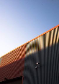 Low angle view of modern building against clear blue sky