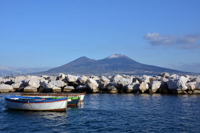 Scenic view of sea and mountains against blue sky