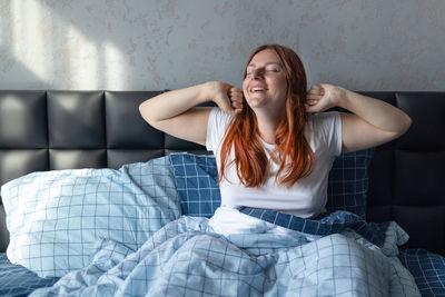 Young woman sitting on sofa at home