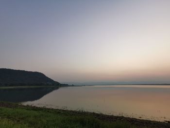 Scenic view of lake against clear sky during sunset