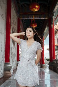 Portrait of young woman standing at temple