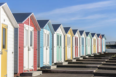 Multi colored beach huts against sky