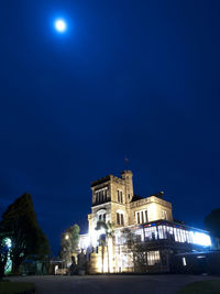 Low angle view of illuminated building against blue sky