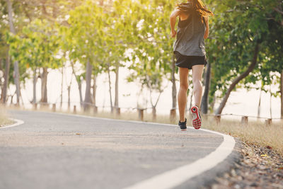 Low section of woman running on road 