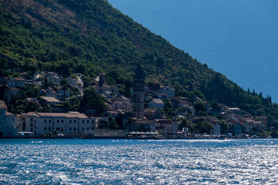 Scenic view of sea by town against clear sky