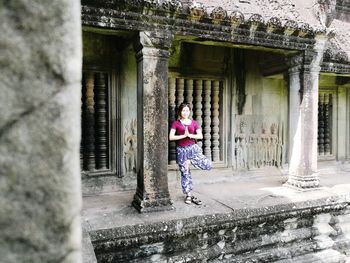 Full length of woman standing in front of building