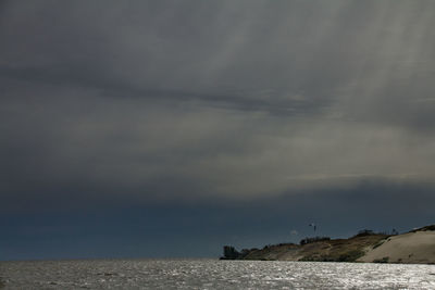 Scenic view of sea against storm clouds