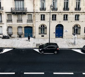 Man walking on road by building in city