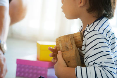 Rear view of preschool boy holding toy .