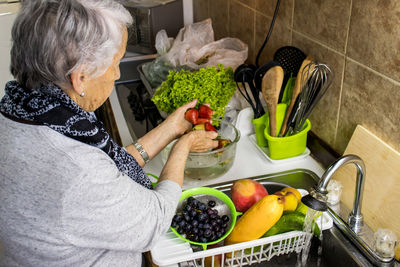 Midsection of woman having food at home