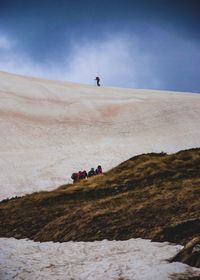 People hiking on desert against sky