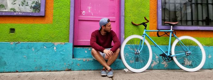 Woman with bicycle in front of building