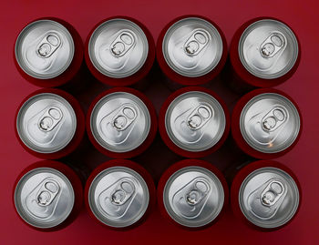 High angle view of drink cans arranged on red table