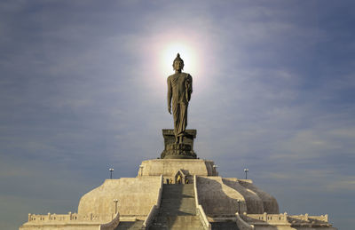 Low angle view of buddha statue against sky