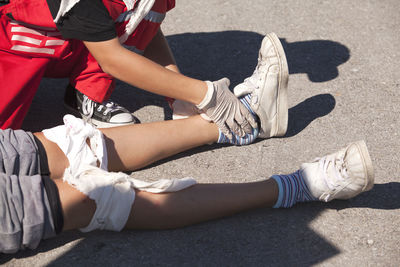 Low section of man adjusting leg on road