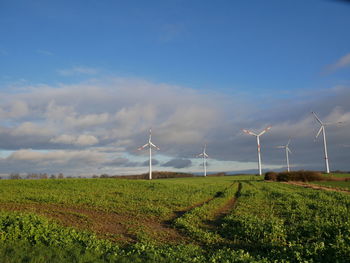 Windmill on field against sky