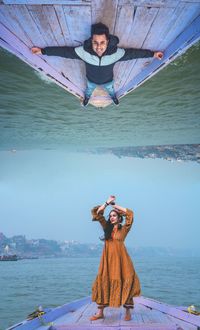 Portrait of woman with arms raised in sea