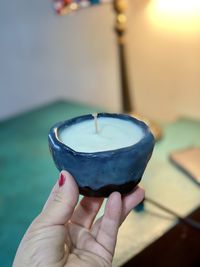 Cropped hand of person holding lit candle