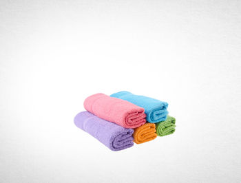 Stack of multi colored towels against white background