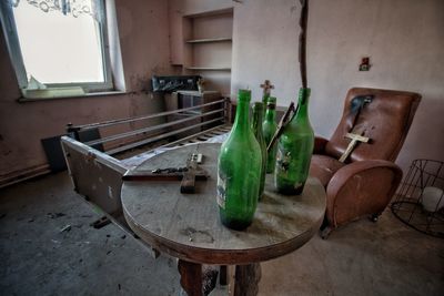 Empty bottles on table by window at home