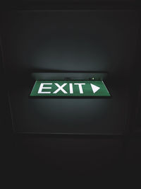 Low angle view of illuminated sign on ceiling