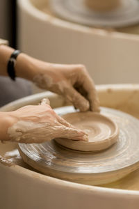 Midsection of woman making craft at table in workshop